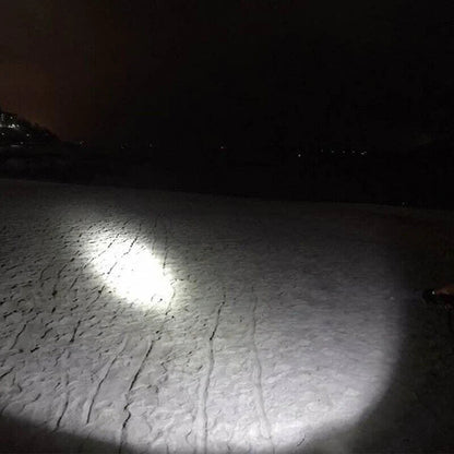Belro Super Blight 90000LM flashlight emitting bright white light in a dark setting, handheld electronic lighting tool.
