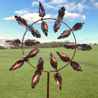 Belro magical metal windmill garden spinner with colorful blades spinning in a garden setting.