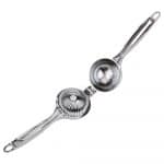 Stainless steel manual citrus press juicer by Belro for oranges and lemons, shown on a kitchen countertop with halved citrus fruits.