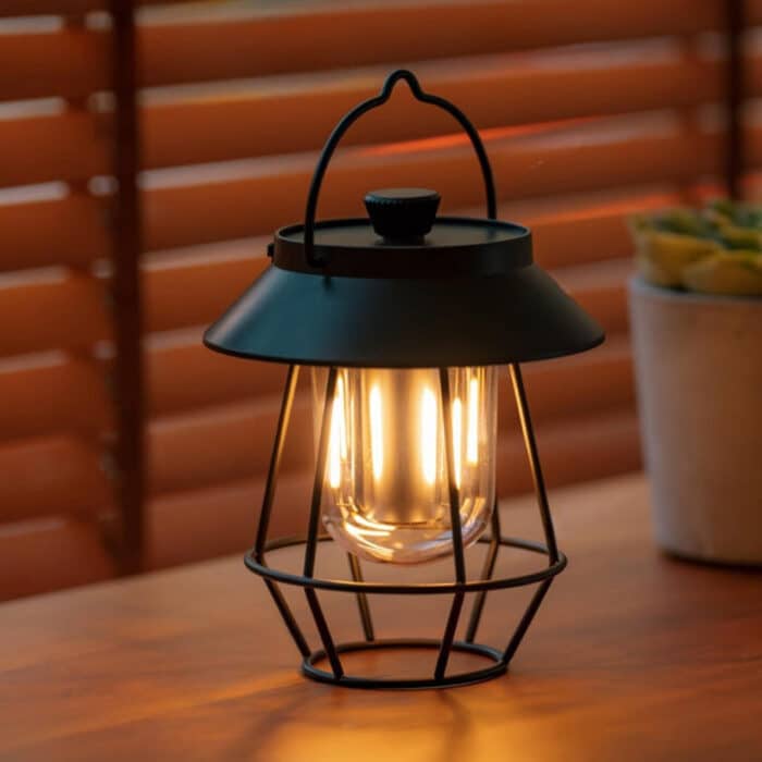 Wireless USB outdoor table lamp by Belro with modern design, illuminated and placed on a patio table outdoors.