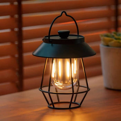 Wireless USB outdoor table lamp by Belro with modern design, illuminated and placed on a patio table outdoors.