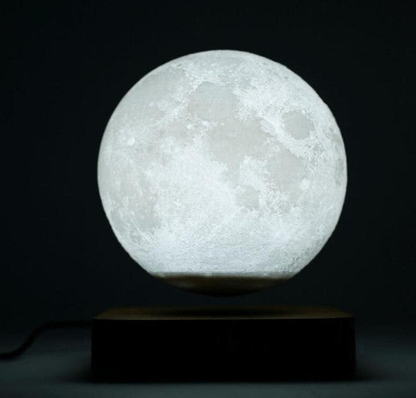 Belro magnetically levitated lunar lamp glowing softly in a dark room, showcasing its futuristic design and floating moon shape.