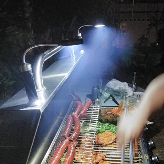 Belro magnetic barbecue LED light attached to a man’s clothing, providing hands-free illumination for grilling in low light.