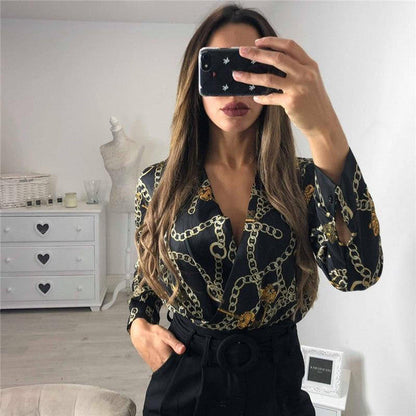 Vintage printed Belro bodysuit featuring floral patterns and fitted design, displayed on hanger against a neutral background.