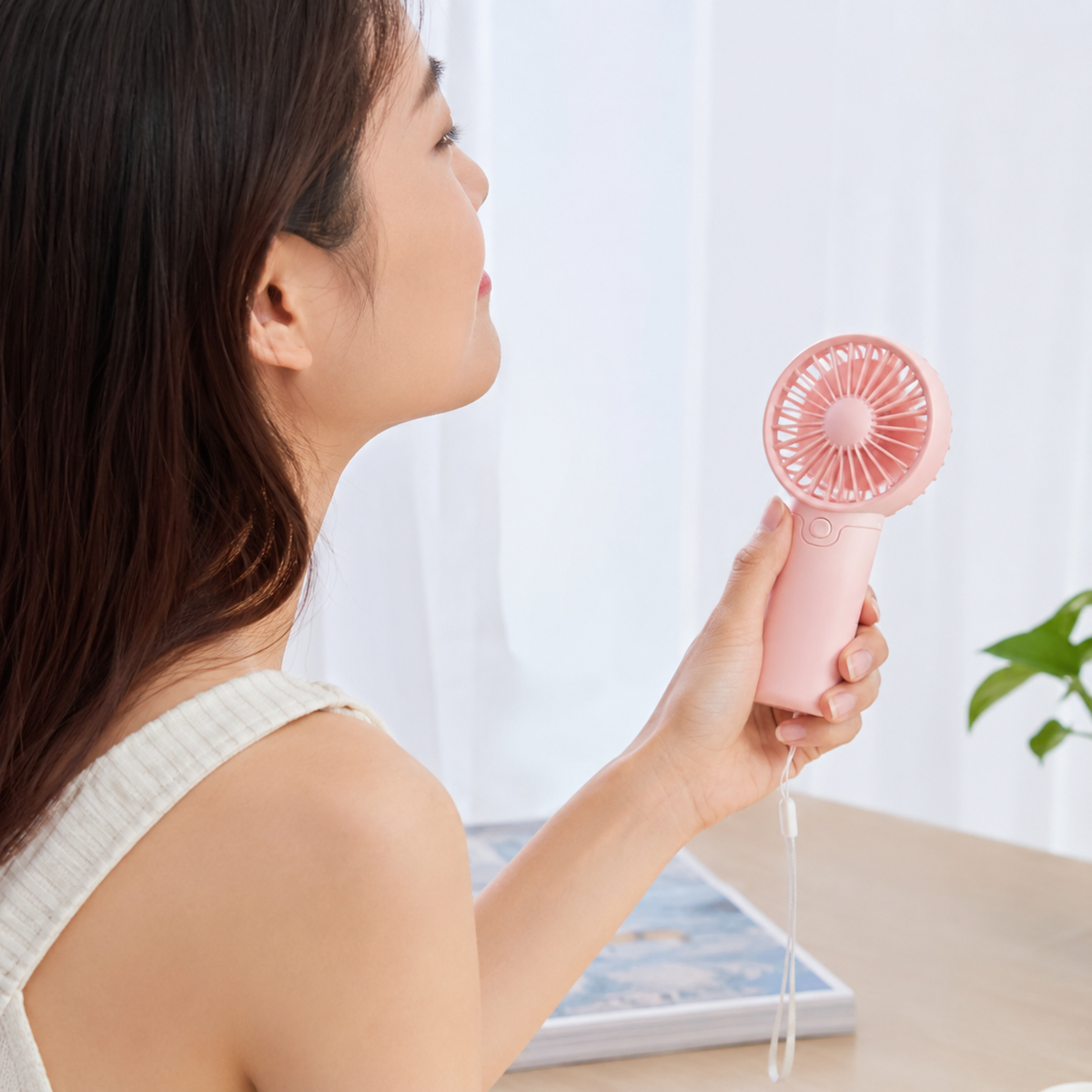 DecorsDeluxe ZenWave Traveler portable mini handheld fan with battery power for travel and personal cooling.