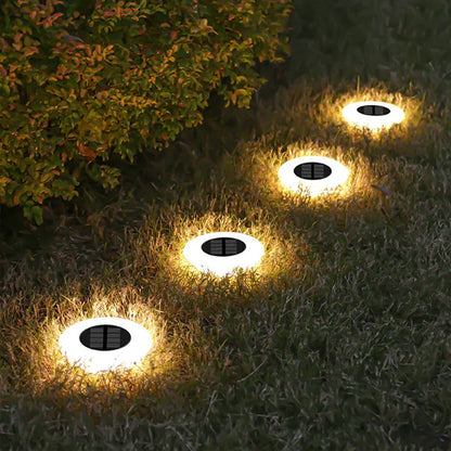 Mivoza solar ground lights 4-pack with 14 LEDs and 360° illumination, installed in a garden for outdoor lighting.