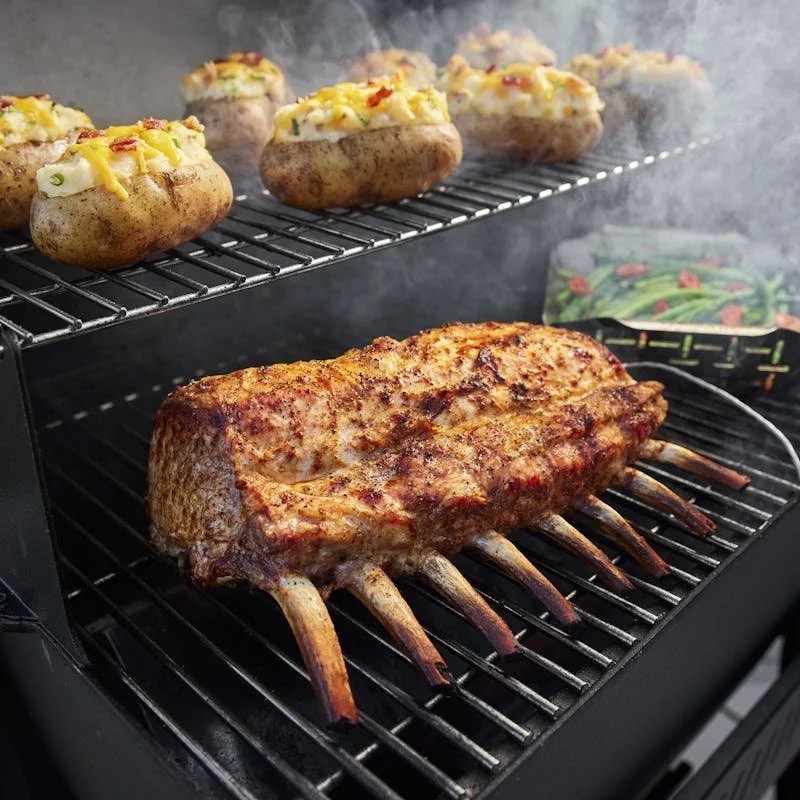 Casavibeo Weber Searwood 600 pellet grill with bone-in pork roast on a cutting board, ready for grilling.