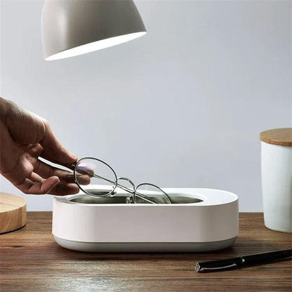 Portable ultrasonic cleaner from Belro for jewelry cleaning, compact device with stainless steel basin and ultrasonic technology.