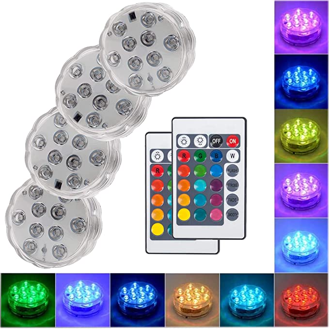 Set of four Belro submersible LED pool lights in a backyard pool, illuminating the water with vibrant colors.