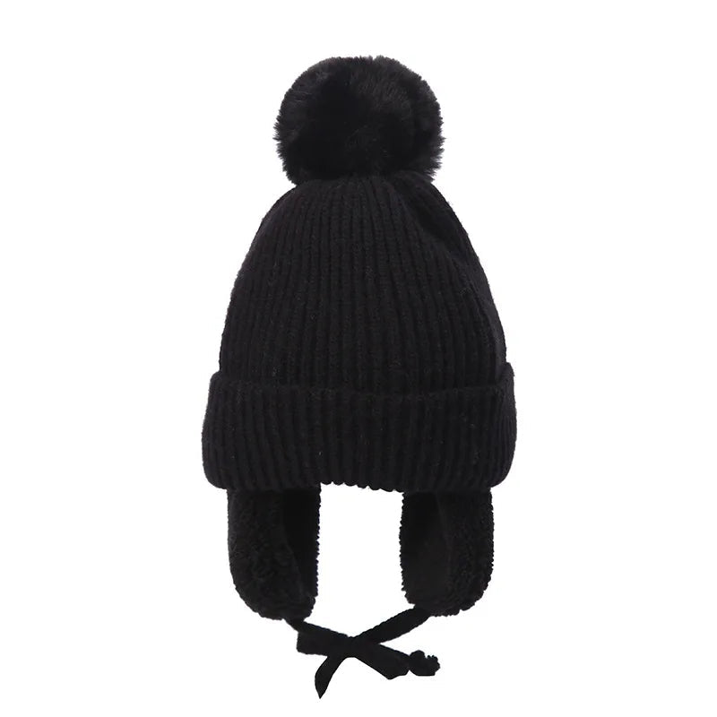 Black kids knit beanie winter hat with earflaps from Belro, designed for warmth and comfort in cold weather.