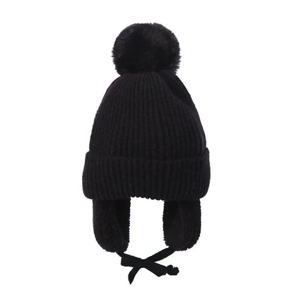 Black kids knit beanie winter hat with earflaps from Belro, designed for warmth and comfort in cold weather.
