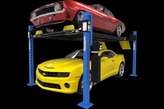 Dannmar D4-9 four-post lift with 9,000-lb capacity, shown in a workshop setting, featuring sturdy metal posts and safety features.