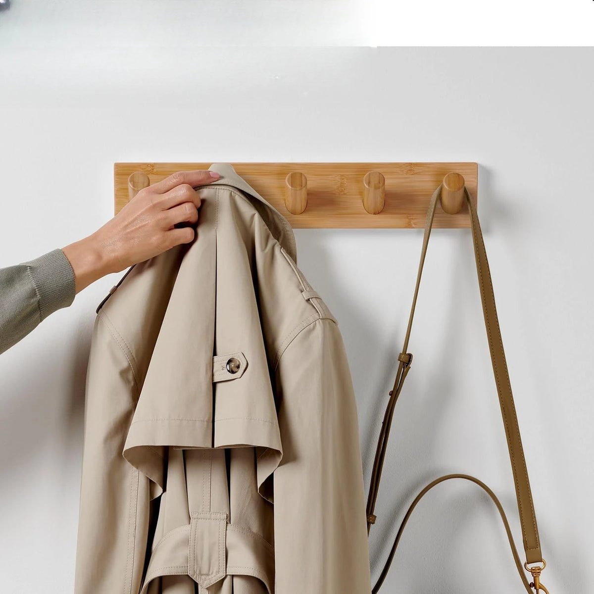 Wooden wall-mounted coat hook rack with five hooks, ideal for jackets and coats, by Belro, mounted on a plain wall.