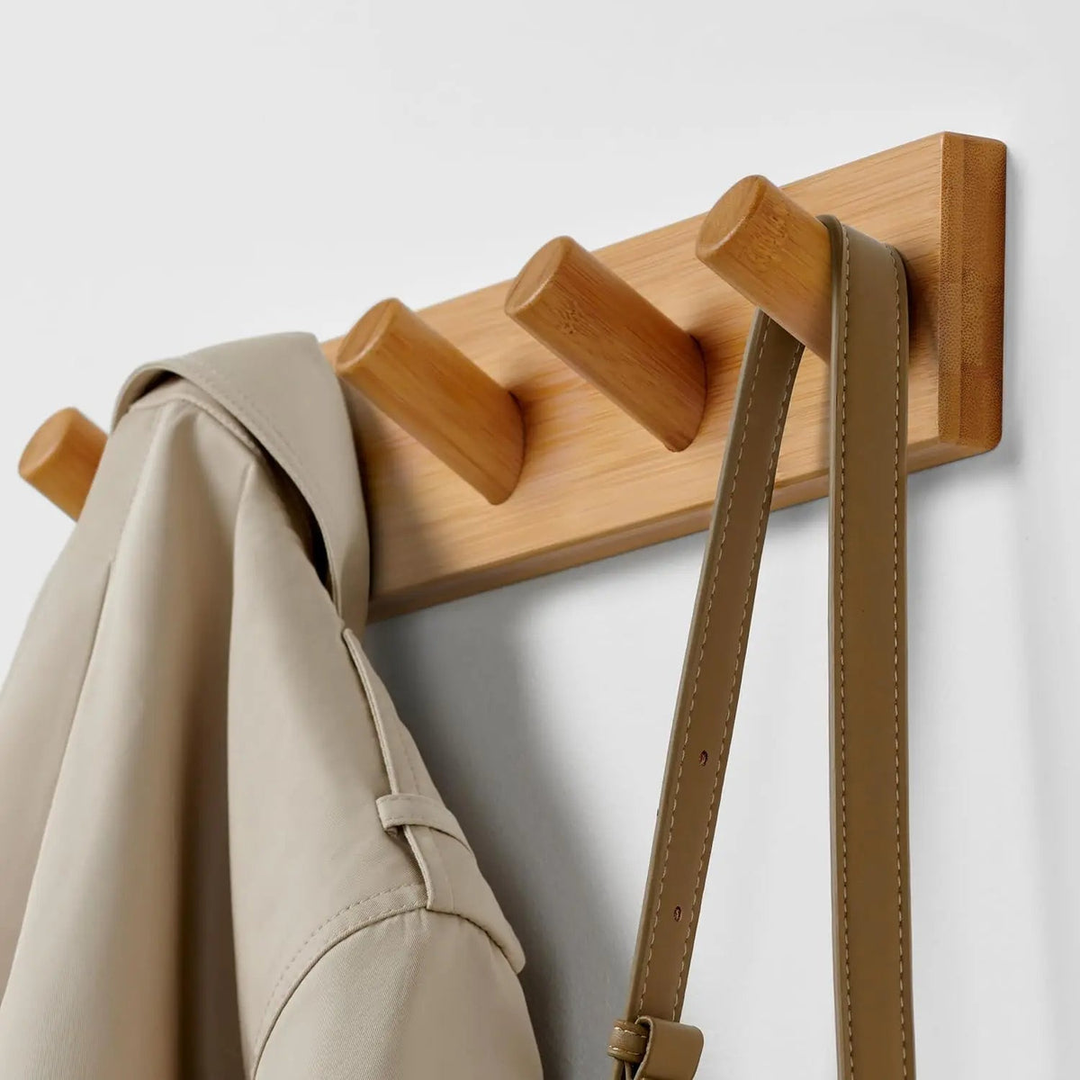 Wooden wall-mounted coat hook rack with five hooks from Belro, perfect for hanging jackets and coats in a clothing entryway.