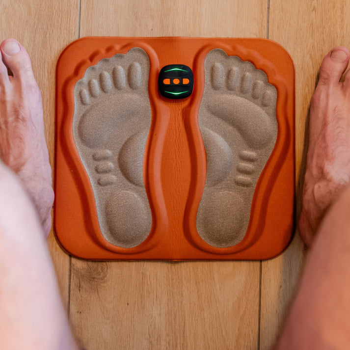 Mivoza Deutschland foot stimulator for neuropathy pain relief, portable and rechargeable device with electrode pads on foot.