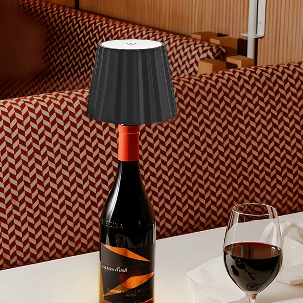 Belro wine bottle table lamp with integrated flashlight feature, illuminated and resting on a wooden surface.