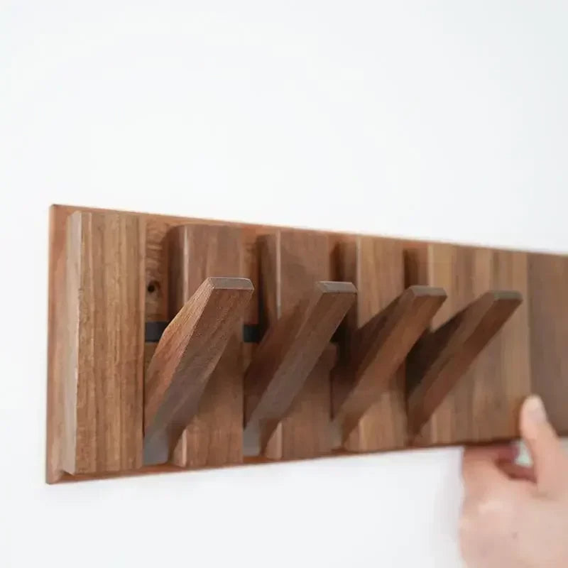 Wooden wall-mounted coat rack with multiple hooks for jackets and coats, branded Belro, mounted on a light-colored wall.