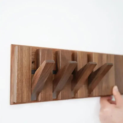 Wooden wall-mounted coat rack with multiple hooks for jackets and coats, branded Belro, mounted on a light-colored wall.