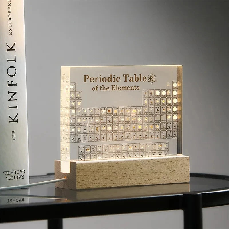 Acrylic periodic table display with wooden light base, designed for pet supplies, featuring colorful element blocks on a sleek surface.