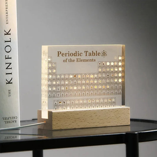 Acrylic periodic table display with wooden light base, designed for pet supplies, featuring colorful element blocks on a sleek surface.