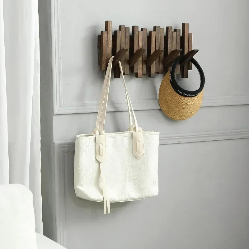 Belro natural wood wall-mounted coat hook rack with flip-down coat holder for jackets and coats, shown mounted on a wall.