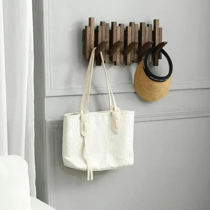 Belro natural wood wall-mounted coat hook rack with flip-down coat holder for jackets and coats, shown mounted on a wall.