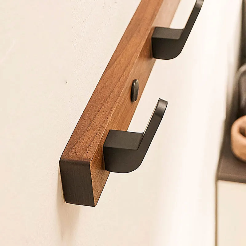 Belro minimalist wall-mounted coat hook with wood and metal design, perfect for hanging jackets and coats in an entryway or hallway.