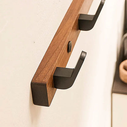 Belro minimalist wall-mounted coat hook with wood and metal design, perfect for hanging jackets and coats in an entryway or hallway.