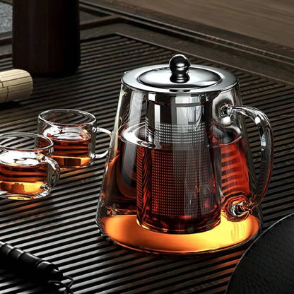 Belro heat resistant glass teapot for kitchen and dining, showcasing a clear glass teapot with a handle and lid on a wooden surface.
