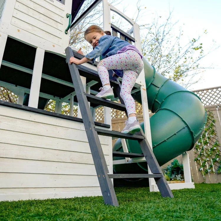Casavibeo Kidkraft Wrangler Way Swing Set with slides, swings, and climbing features for kids in a backyard play area.