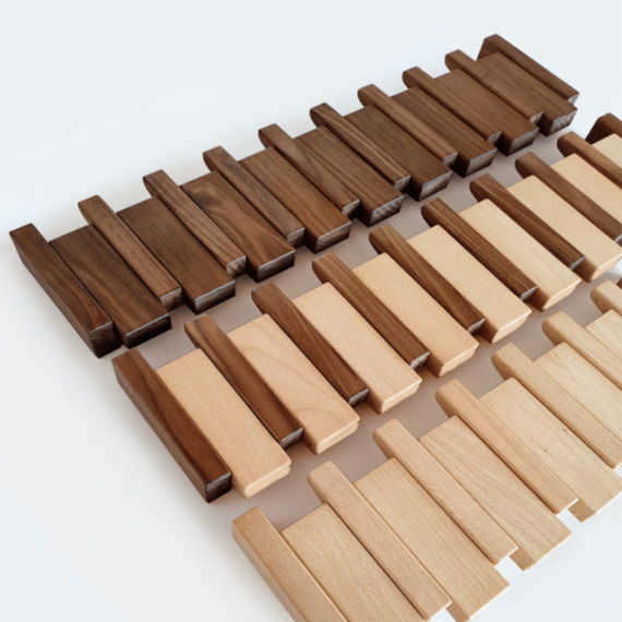 Handmade wooden coat rack by Belro with multiple hooks for jackets and coats, mounted on a wall in a modern entryway.