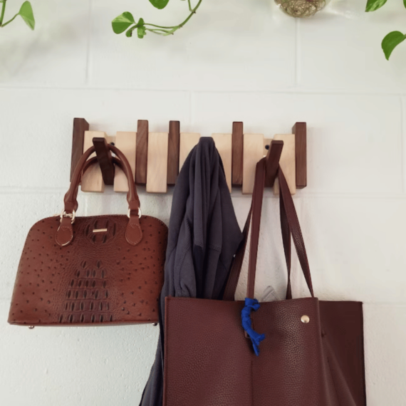 Handmade wooden coat rack by Belro with multiple hooks for jackets and coats, mounted on a wall for organized storage.