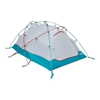 Casavibeo Mountain Hardwear Trango 2 tent set up outdoors with rainfly and stakes in a scenic mountain camping area.