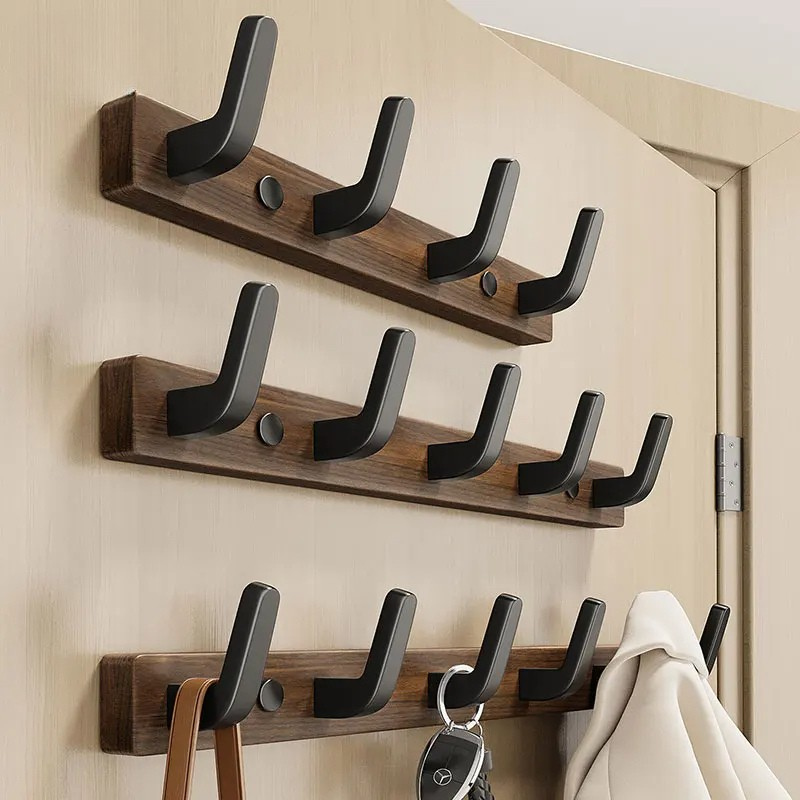 Minimalist wall-mounted coat hook by Belro with wood and metal design for hanging jackets and coats.