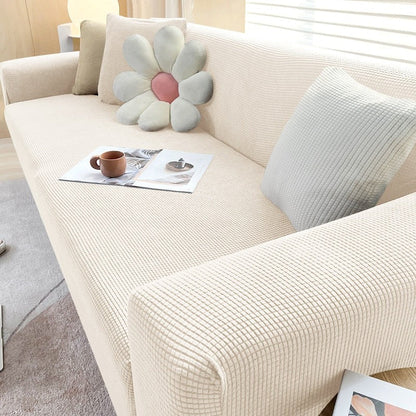 Stretchable Belro sofa cover drapes over a sofa, protecting and enhancing the furniture with a snug, fitted design.