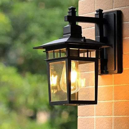 Belro outdoor wall light mounted on exterior wall, with a sleek metal finish and clear glass shade for outdoor garden lighting.
