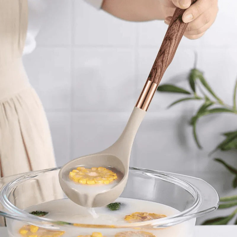 Belro kitchen utensil set with wooden handles including spatulas, spoons, and tongs on a kitchen countertop.