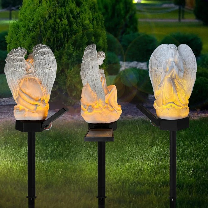 Belro Solar Angel Garden Light illuminating a garden at dusk, decorative outdoor night light with angel design.