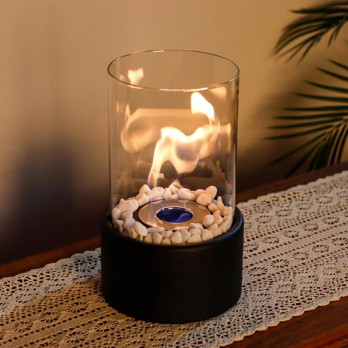 Belro portable glass tabletop fireplace for outdoor use, showcasing a sleek design with clear glass panels and a burning flame.