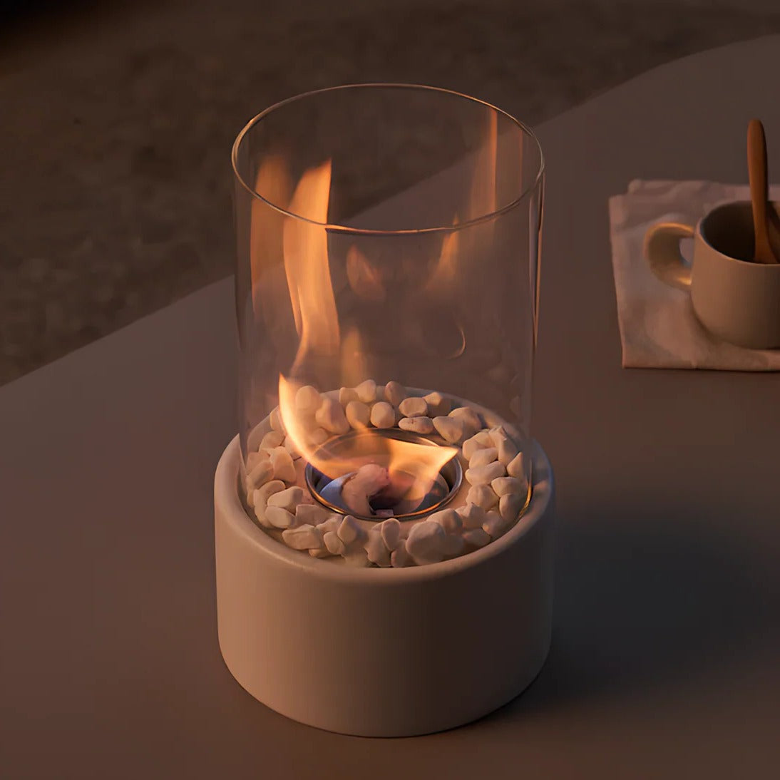 Belro portable glass tabletop fireplace for outdoor use, featuring a sleek design with clear glass sides and a burning fuel source inside.