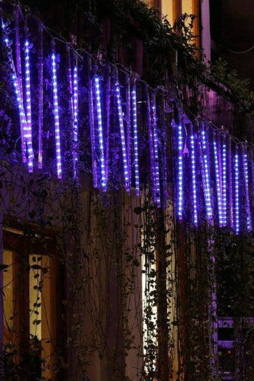 Belro LED Dripping Icicle Lights hanging outdoors, creating a festive, sparkling holiday ambiance in a garden setting