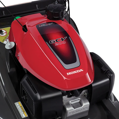 Honda HRX217VKA 21-inch gas self-propelled lawn mower with 200cc engine, shown in a yard setting.