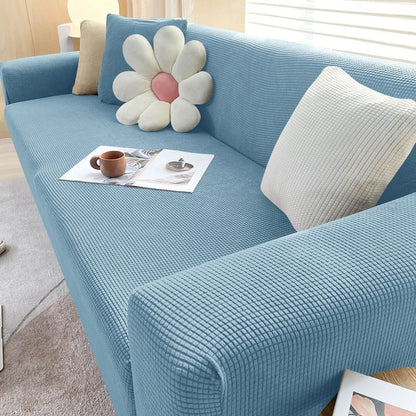 Stretchable Belro sofa cover in neutral color showing fitted design on a modern sofa in a home living room setting.