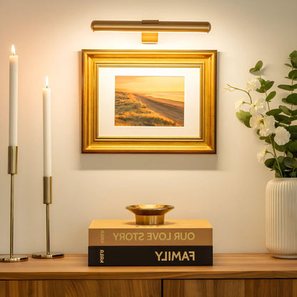 Wireless LED picture light by Belro mounted on a wall, illuminating artwork in an outdoor home and garden setting.