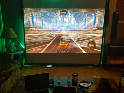 Belro Mini Movie Projector displaying a movie on a wall, compact electronics device for home entertainment and presentations.