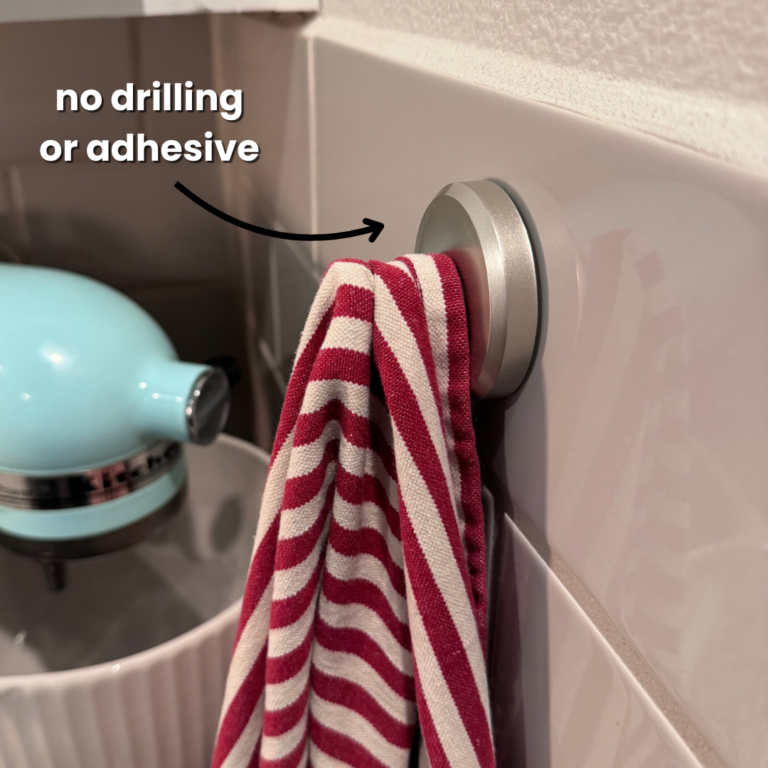Belro Instant Grip suction hooks attached to a tiled wall for organizing kitchen or bathroom items.