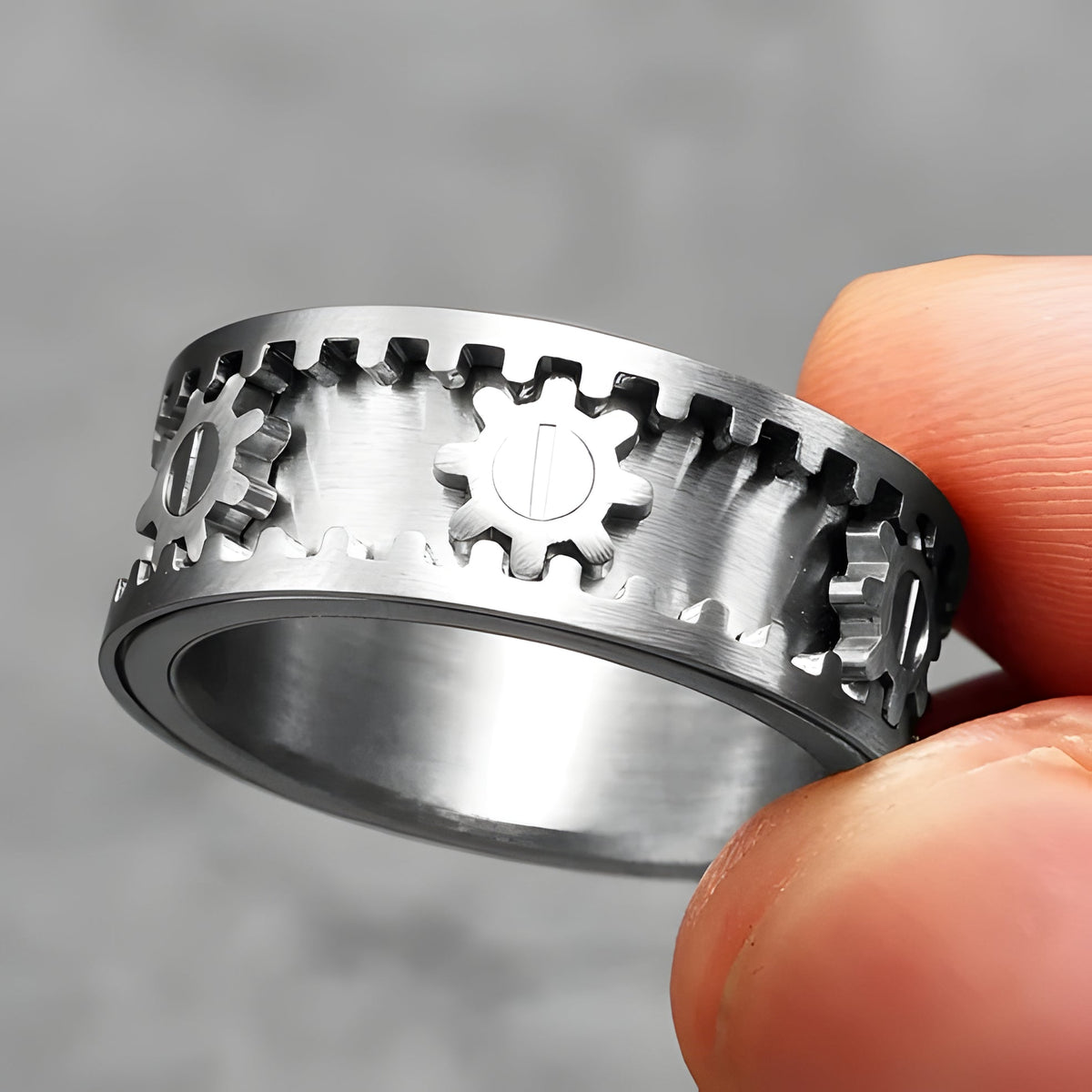Belro Gear Ring spinner jewelry, metallic accessory with gear design, close-up view showing intricate details and polished finish.