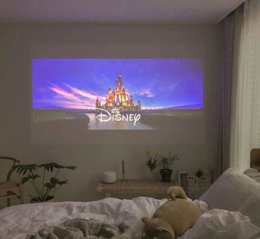 Belro Mini Movie Projector displaying a colorful movie scene on a wall, compact electronics device for home entertainment.