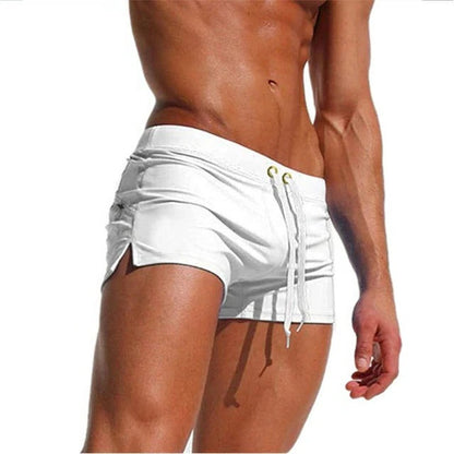 Men's Belro quick-drying swim trunks with a vibrant blue and green tropical print, displayed on a hanger.