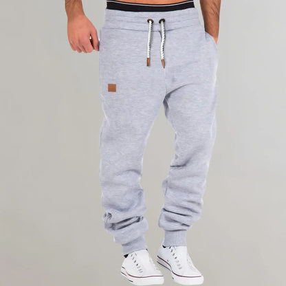 Men's Belro jogging pants in black, made of lightweight activewear fabric, shown on a model standing outdoors.